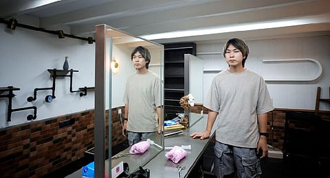 Li Menghua, a barbershop owner poses for a picture at his closed barber shop after the lockdown