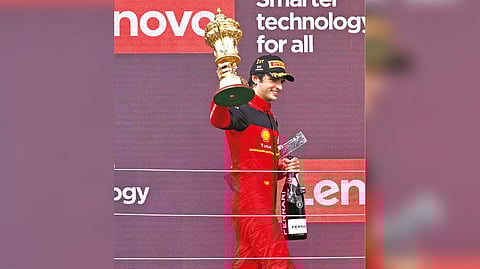 Ferrari?s Spanish driver Carlos Sainz Jr holds aloft the trophy on the winners? podium