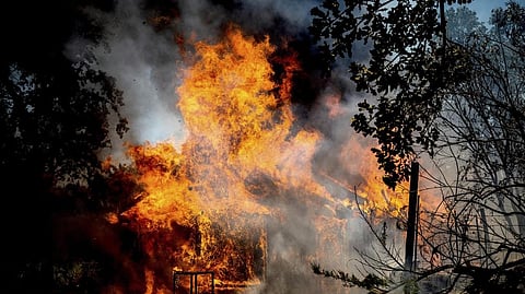 Flames from the Oak Fire consume a home on Triangle Road in Mariposa County, Calif