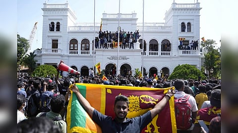 Protesters stand on the balcony outside Sri Lankan Prime Minister Ranil Wickremesinghe's office