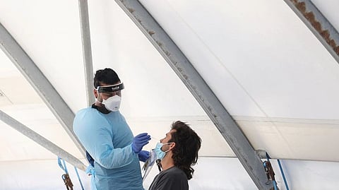 A health worker administers a test for Covid on a member of the public at the Bondi Beach drive-through testing centre during a Covid outbreak lockdown in Sydney.