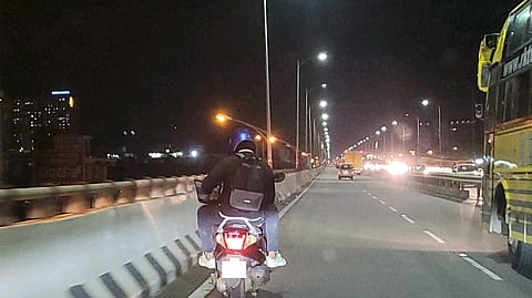 A LinkedIn user shared a photo of a man using laptop while riding pillion