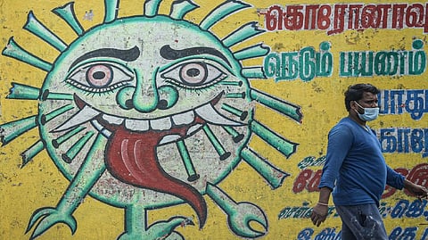 A man walks past a Coronavirus awareness mural in Chennai