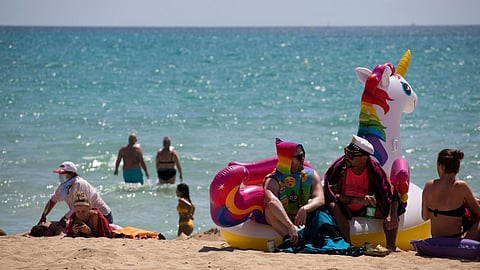 Tourists sunbathe on the beach at the Spanish Balearic Island of Mallorca