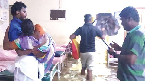 A relative carries a woman patient while shifting her from an inundated ward in Rasipuram Government Hospital in Namakkal on Monday