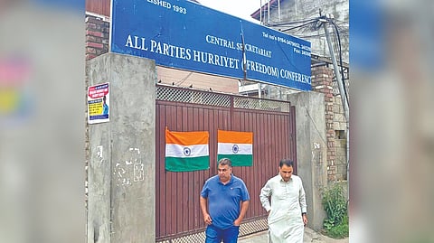 Political activist affixes flag on Hurriyat office