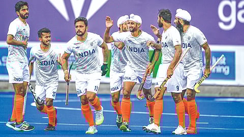 Indian hockey players celebrate after scoring a goal against Wales