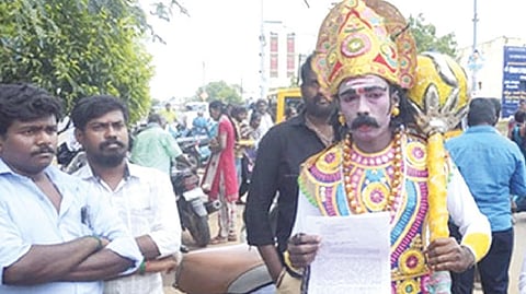 Activist Pon Muthukumar in Lord Yama attire with a petition to the Collector in Karur on Monday