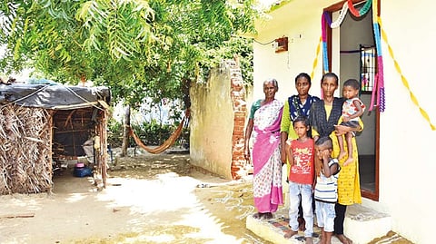 One of the Irula family beneficiaries in front of the new house