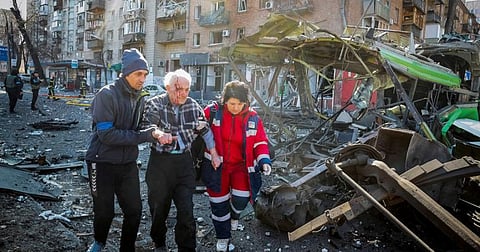 People and medics help a wounded resident of a house destroyed by shelling as Russia's attack on Ukraine