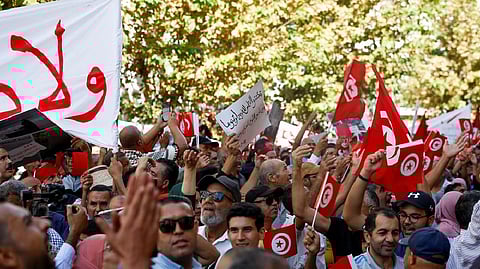 Supporters of Tunisia's Islamist opposition party Ennahda carry signs and flags during a protest against Tunisian President Kais Saied