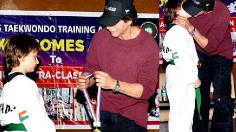 SRK putting the medal around AbRam; SRK kisses AbRam