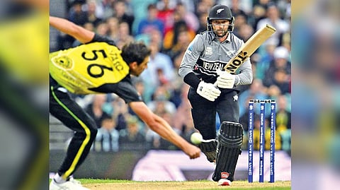 Australia?s Mitchell Starc (left) fields the ball as New Zealand?s Devon Conway runs between the wickets