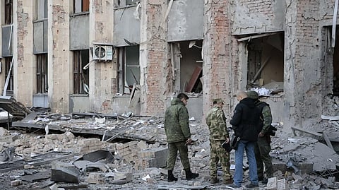 Investigators inspect a site after shelling near an administrative building