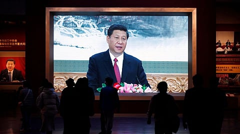 Visitors walk past a screen showing Chinese President Xi Jinping at the Museum of the Communist Party of China in Beijing