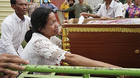 Mother of Son Sophat, a teen victim of a boat accident, cries by her daughter's coffin during a funeral procession in Koh Chamroeun village, east of Phnom Penh, Cambodia on Friday.