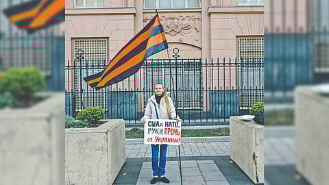 A woman holding a poster that says ?U.S., NATO, Hands Off Ukraine? in front of the United States Embassy in Moscow.
