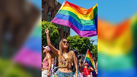 A girl holding a LGBTQ flag