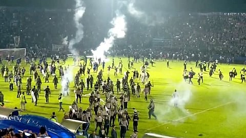 Fans invade the soccer field after a match between Arema FC and Persebaya Surabaya at Kanjuruhan Stadium, Malang