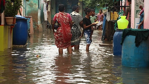 People wading through flooded street