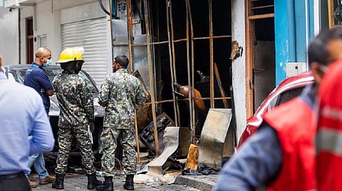 Firefighters and emergency personnel stand outside a building after a major fire swept through cramped living quarters of foreign workers in the Maldives capital Male on November 10, 2022.