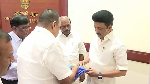 CM Stalin inspecting at the new designs in dhotis and sarees with  ministers E V Velu and R Gandhi.