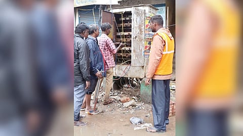 Tangedco staff working on a junction box kept on the main road in the city