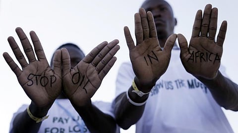 Demonstrators show "stop oil in Africa" written on their hands during a protest with Stop Pipelines coalition against pipelines in East Africa