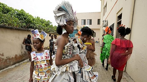 Models wearing outfits made from various recycled materials wait backstage before a 'trashion show' in Sangotedo Lagos, Nigeria.