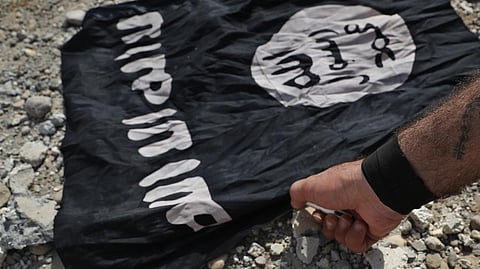 A fighter from the Christian Syriac militia that battles the Islamic State group under the banner of the US-backed Syrian Democratic Forces, burns an IS flag on the front line on the western side of Raqqa, northeast Syria, July 17, 2017.