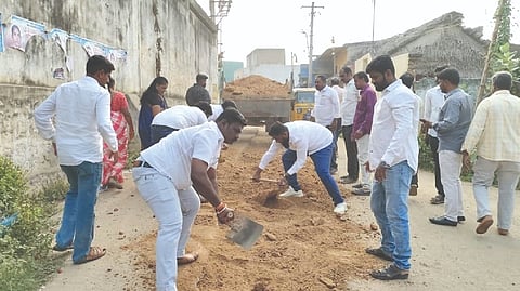 Councillors in Ambur cutting across party lines seen filling up a road with own funds protesting apathy of municipal administration on Monday