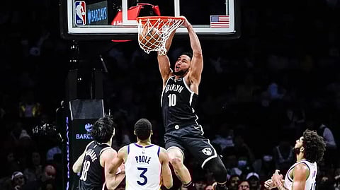 Brooklyn Nets' Ben Simmons (10) dunks the ball in front of Golden State Warriors' Jordan Poole (3) and Anthony Lamb (40) during the first half of an NBA basketball game.