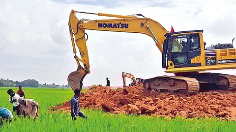 Red soil being dumped on a Samba field for road work in Tiruvaiyaru on Friday