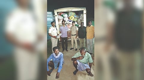 Civil Supplies CID officials with the seized PDS rice and two accused in Tiruvallur on Tuesday.