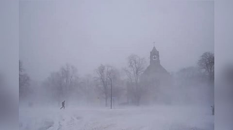 A lone pedestrian in snow shoes makes his way across Colonial Circle as St. John's Grace Episcopal Church rises above the blowing snow amid blizzard conditions in Buffalo, N.Y.