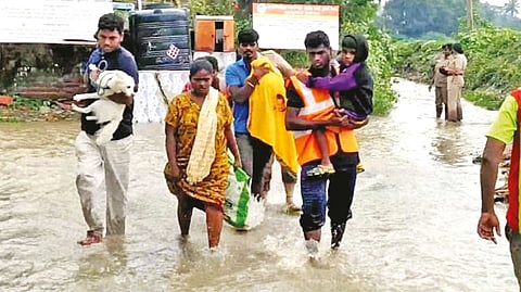 Residents move to relief camps with their pets at a flooded locality in Kancheepuram district