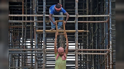 Labourers work at the construction site of a residential building