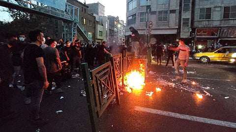 People light a fire during a protest over the death of Mahsa Amini