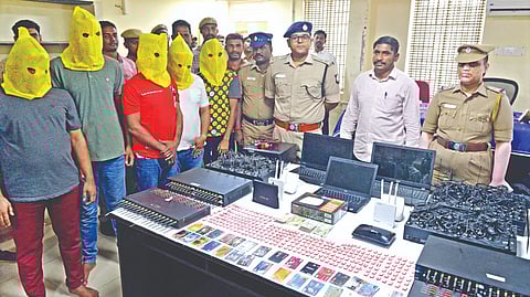 Police displaying arrested loan app scamsters and the materials used by them in Tirupur on Friday