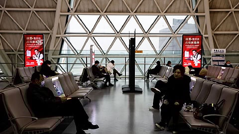 Travellers wait to board their plane at Chengdu Shuangliu International Airport amid a wave of the coronavirus disease infections