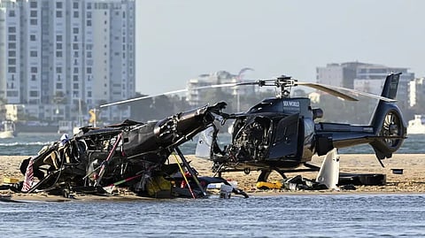 Two cashed helicopters sit on the sand at a collision scene near Seaworld, on the Gold Coast, Australia.