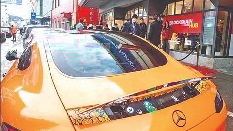 Bitcoin stickers are seen under the spoiler of a sports car standing in
front of the Blockchain Hub Davos 2023 during the WEF