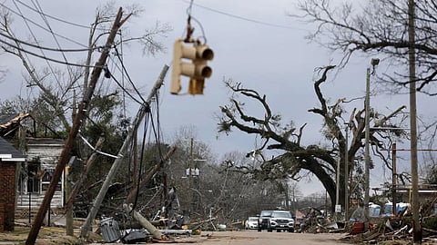 Cars carefully navigate downed trees and power lines on Chestnut Blvd. in Selma, Alab.