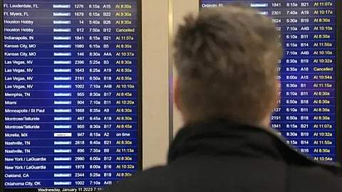 A passenger of Chicago looks at flight information screen at Chicago's Midway Airport that reflects the flight delays stemming from a computer outage at the Federal Aviation Administration on Wednesday,
