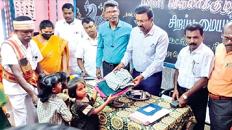Thanjavur Collector Dinesh Ponraj Oliver handing over free uniforms to the students during inauguration.