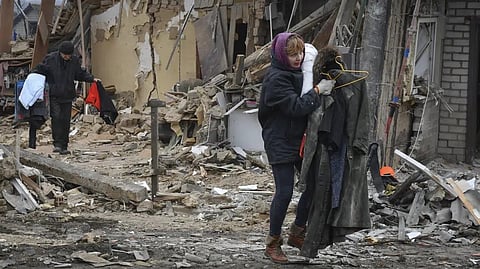 Local residents carry their belongings as they leave their home ruined in the Saturday Russian rocket attack in Zaporizhzhya, Ukraine.