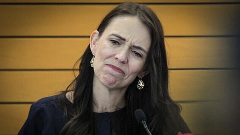 New Zealand Prime Minister Jacinda Ardern grimaces as she announces her resignation at a press conference in Napier.
