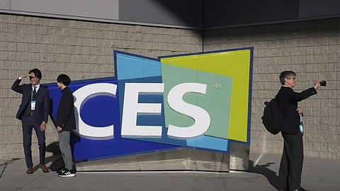 People take pictures in front of a sign during the CES tech show on Jan. 6, 2022, in Las Vegas.