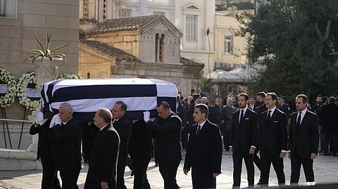 Prince Philippos, walking behind coffin left, Prince Pavlos, center, and Prince Nikolaos, right, sons of former king of Greece Constantine II walk behind their father coffin as they arrive at the Metropolitan cathedral for his funeral in Athens, Monday,