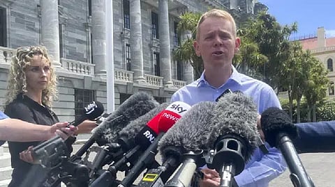 New Zealand Education Minister Chris Hipkins talks to reporters outside parliament in Wellington
